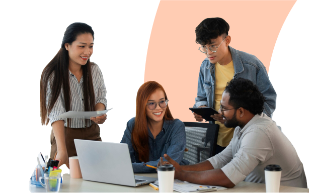 Diverse team of four professionals collaborating around laptop in modern office environment representing career opportunities and team building